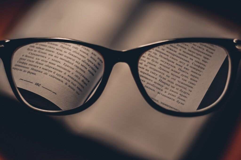 開いた本の上に置かれている眼鏡