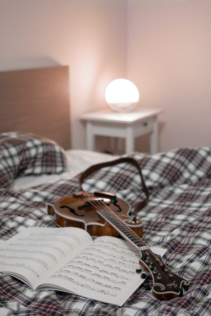ベッドの上に置かれているギターと楽譜