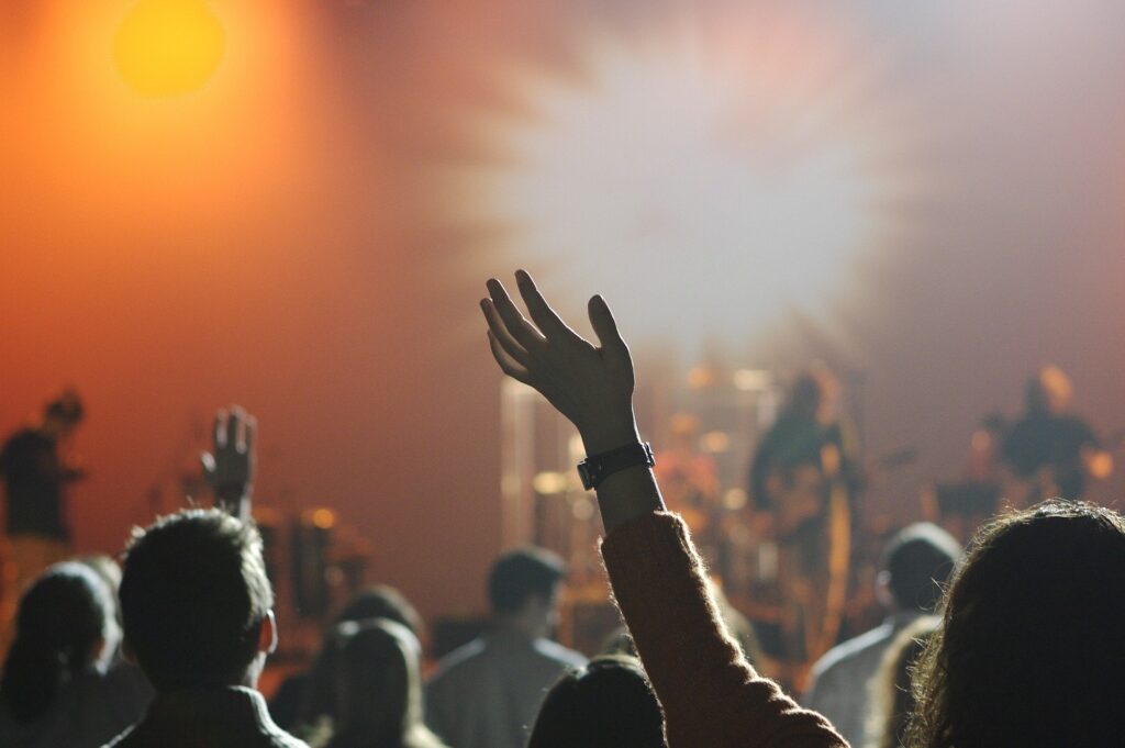 ステージで演奏しているバンドと、手を挙げている観客