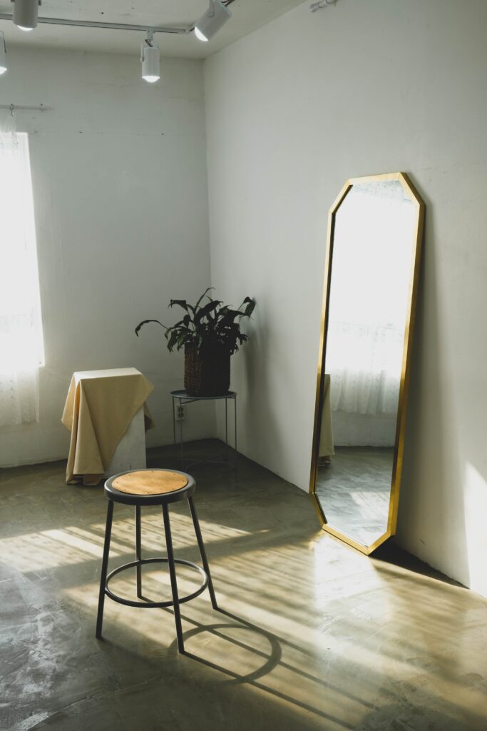 大きい鏡と丸い椅子が置いてある部屋
